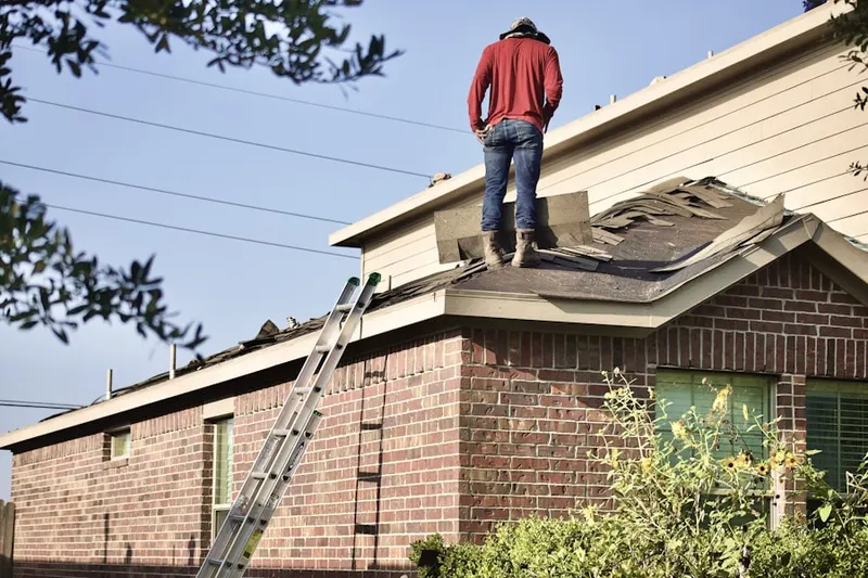 Professional roofer working on a residential roof in West River Park